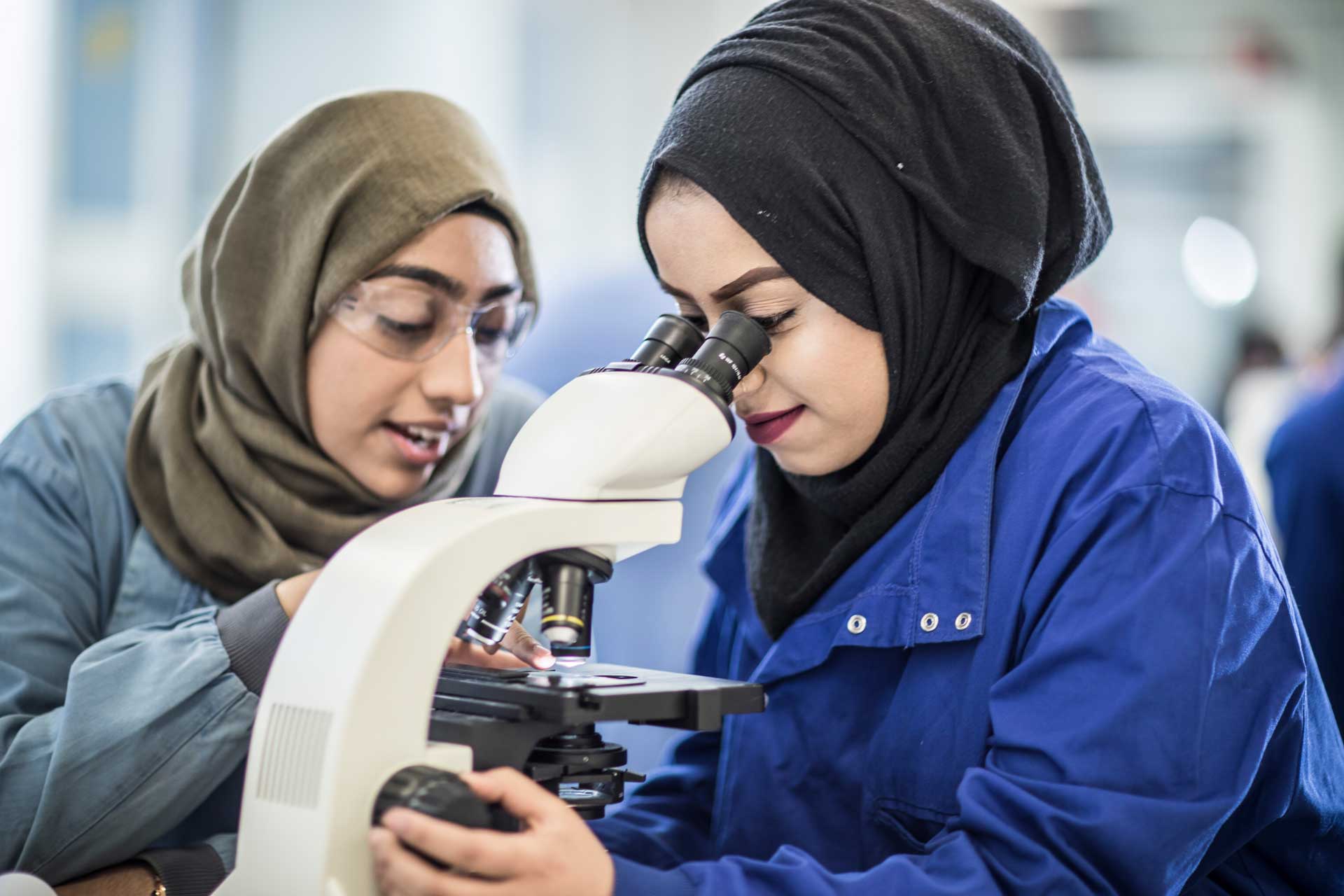 Two students working with a microscope