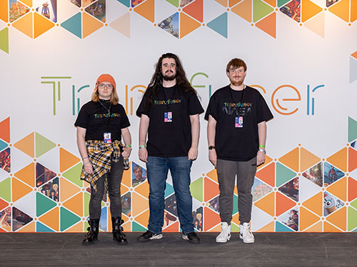 Three people stood against a wall