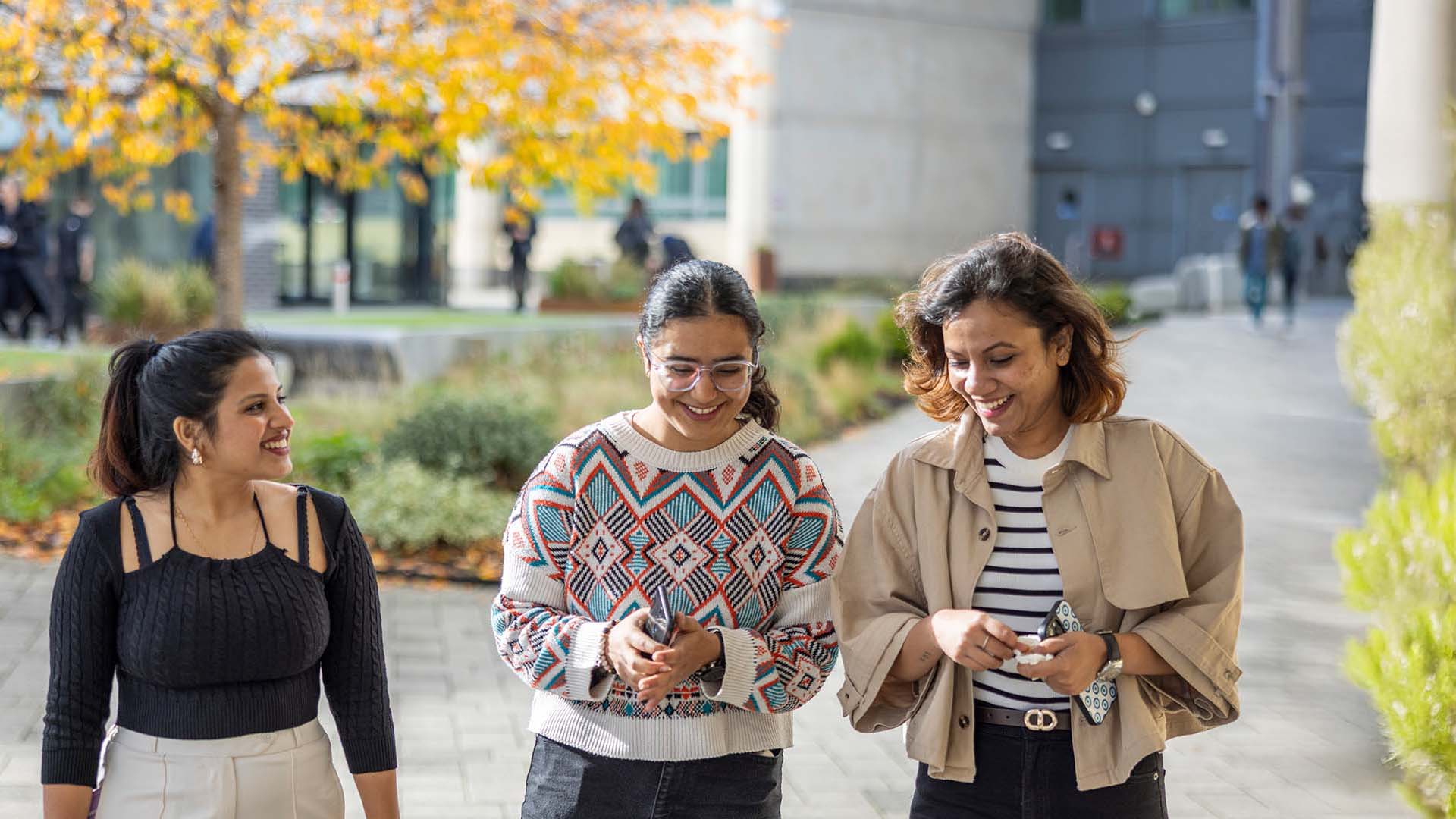 Three students walking through campus