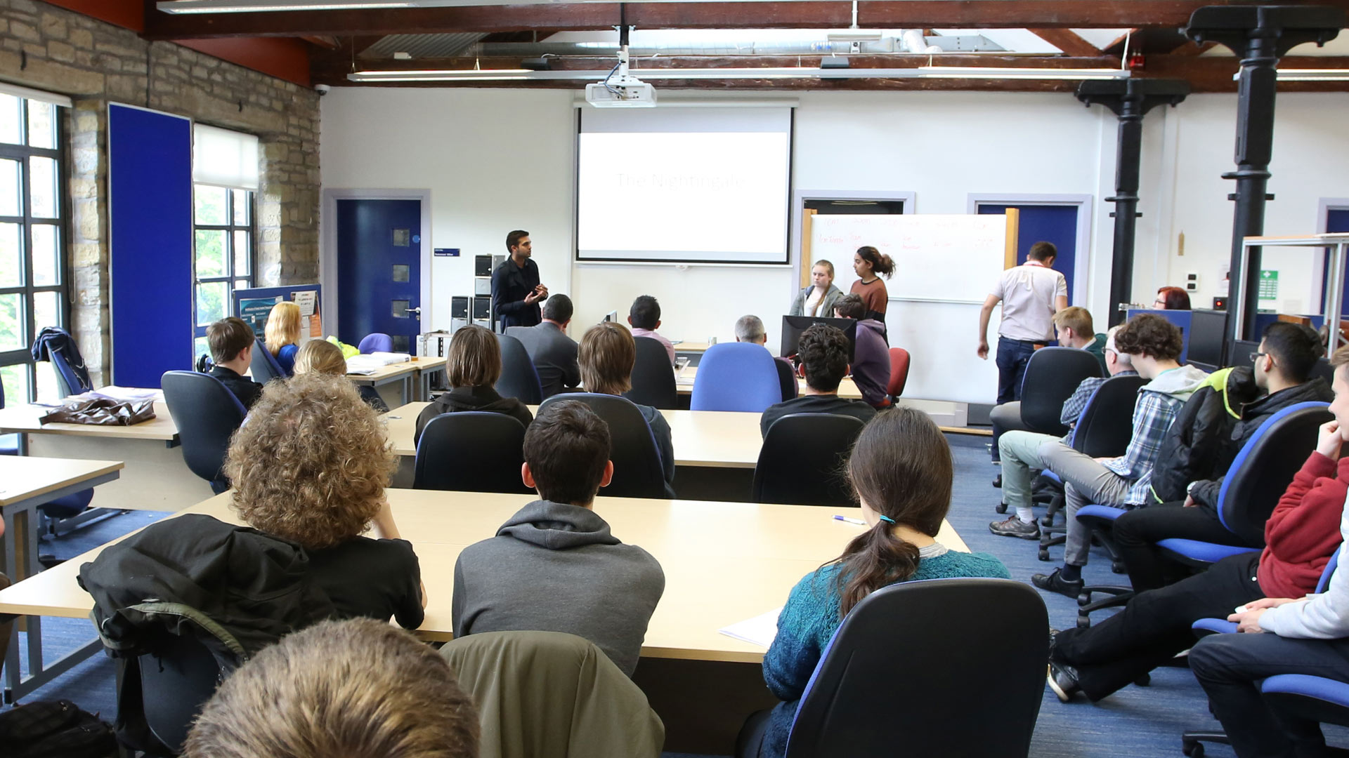 Classroom setting of students delivering a presentation to other students