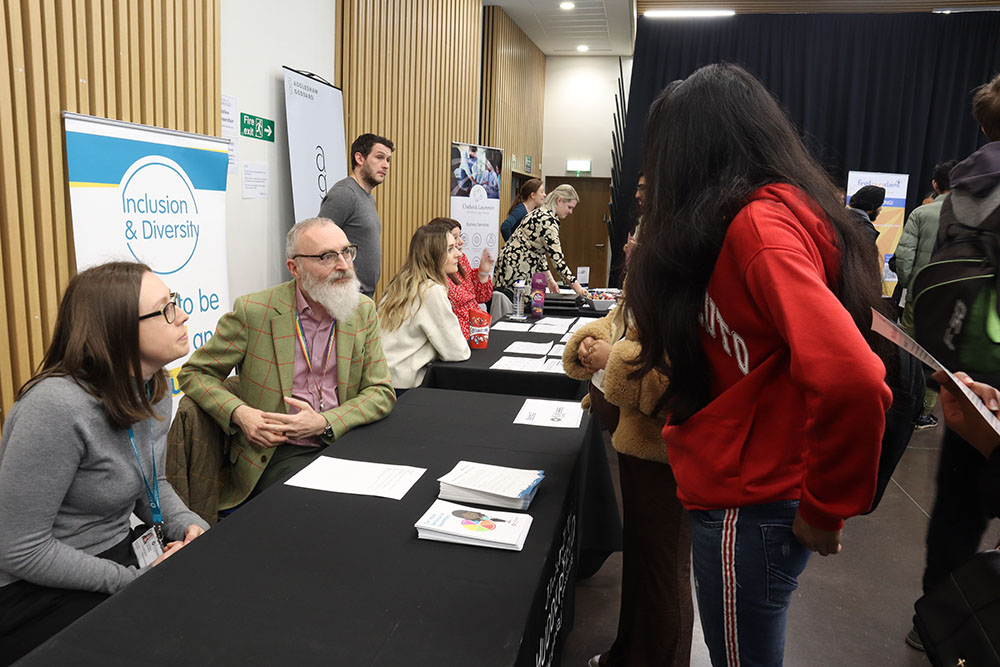 A student talking to Law practitioners at a Law Careers Fair