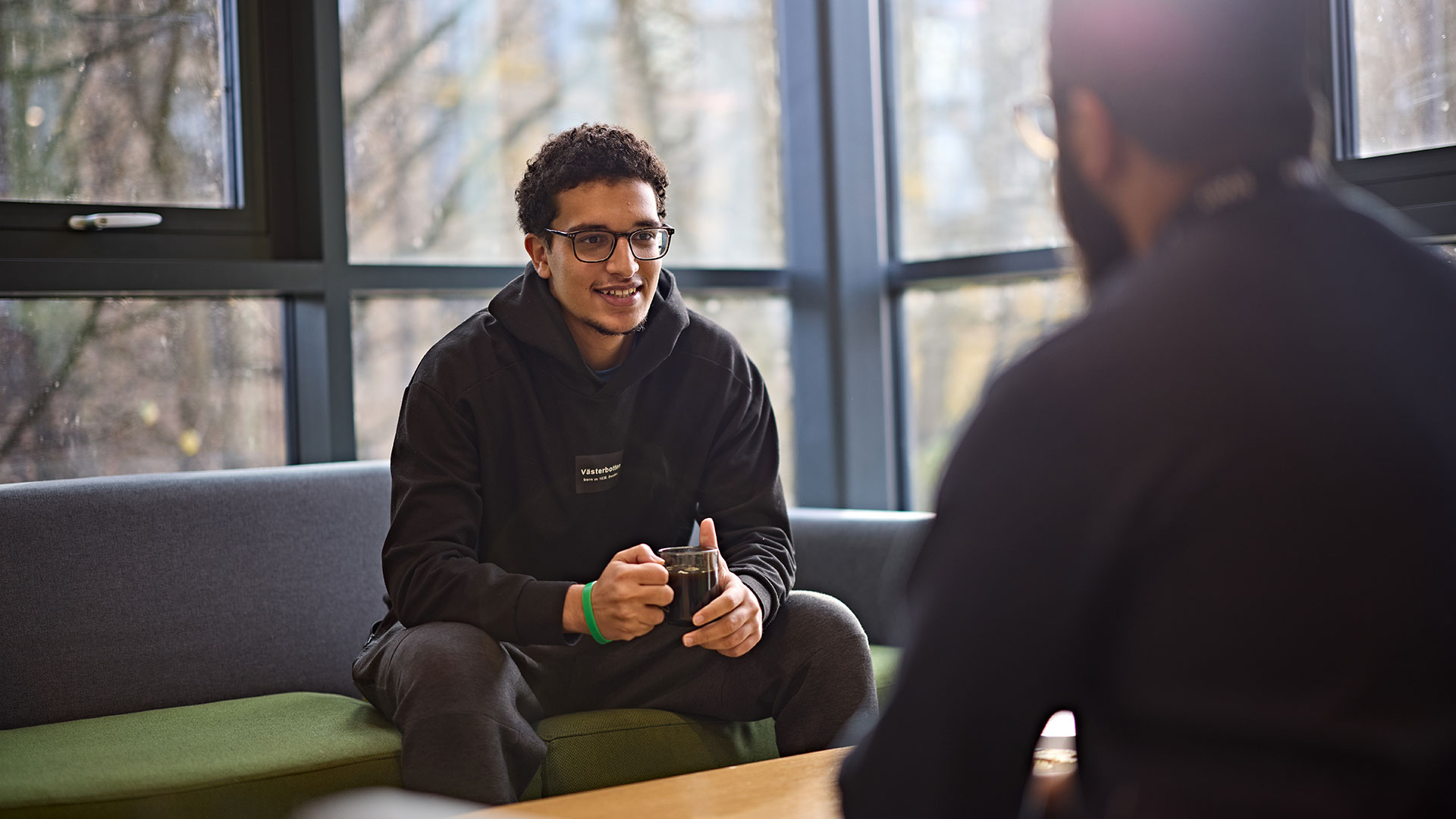 A student chats to the Muslim Chaplain in the communal space.