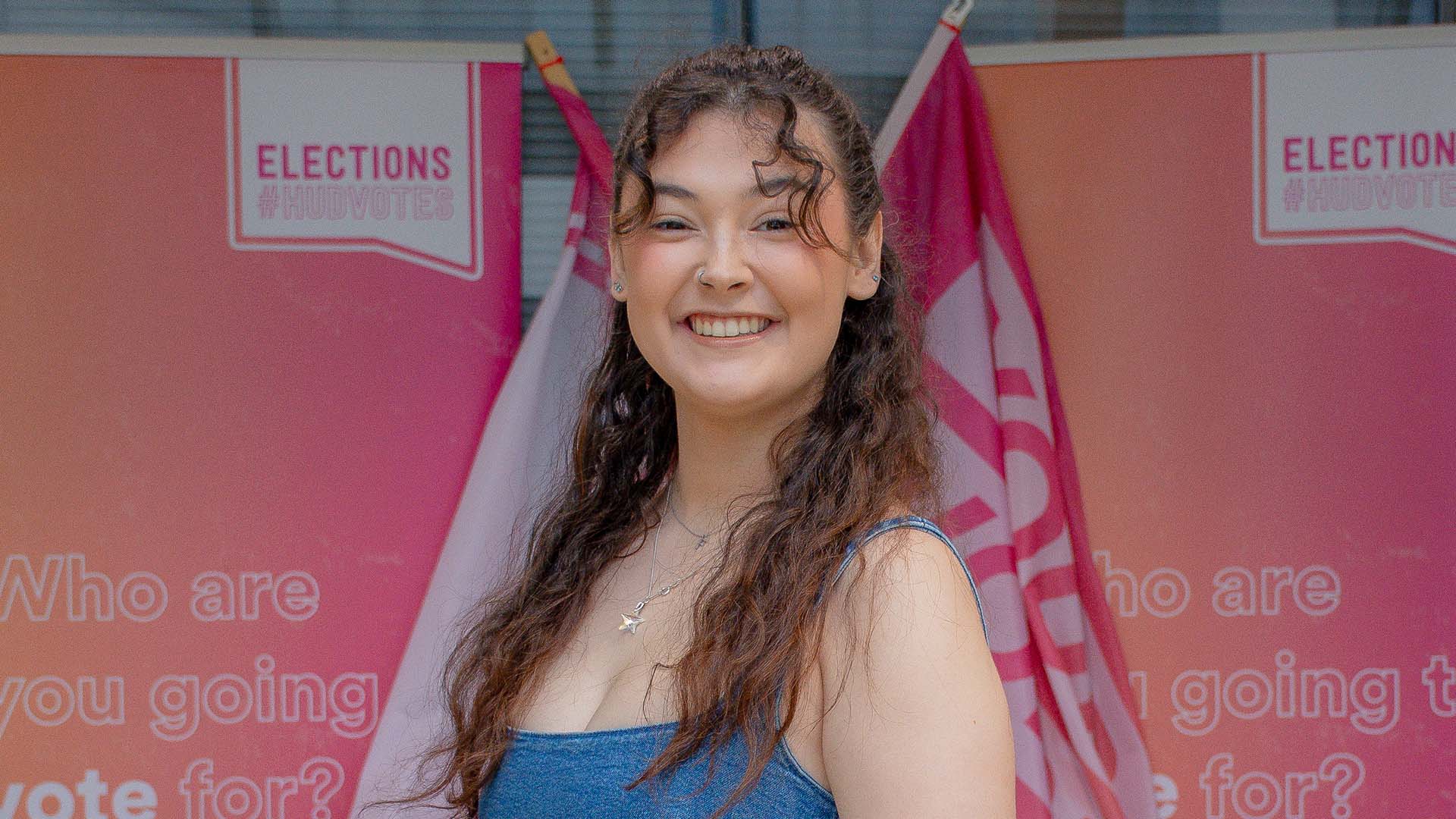 Image of Freya standing in front of elections signage.