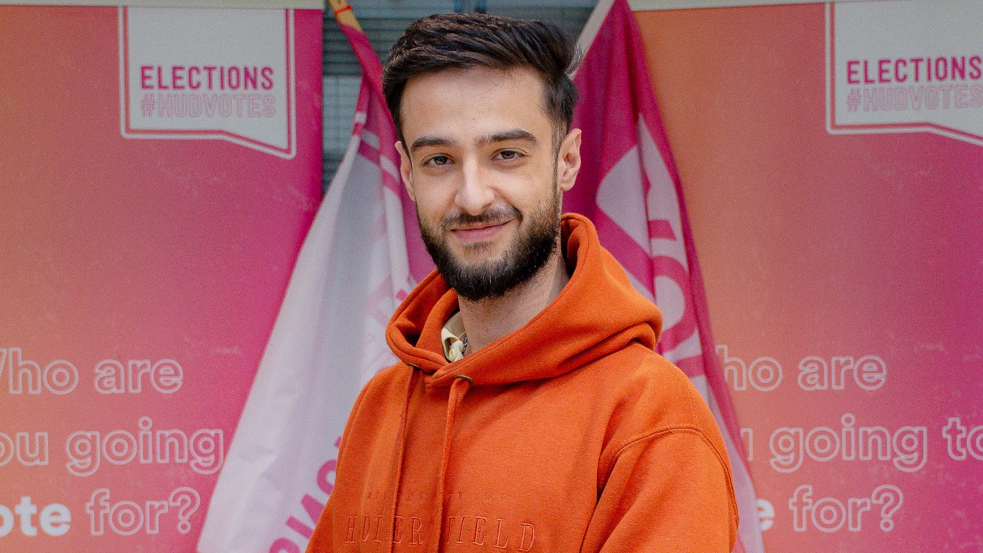 Irfin standing in front of election signage.