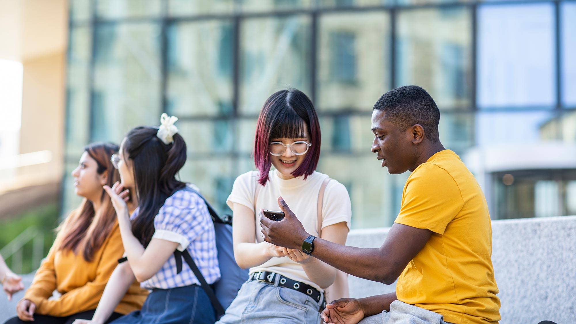 Students look at a mobile phone together