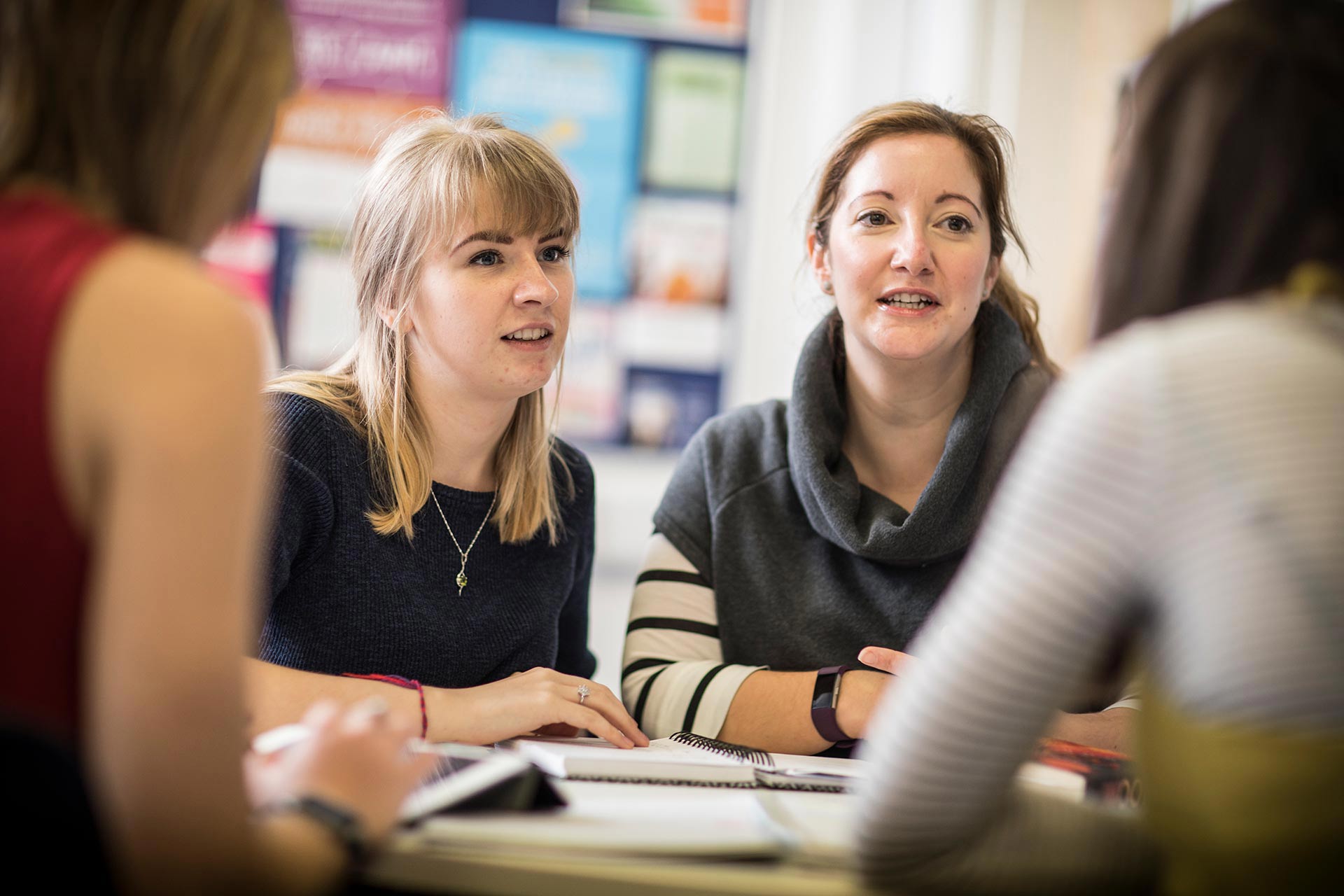 students at a table with books