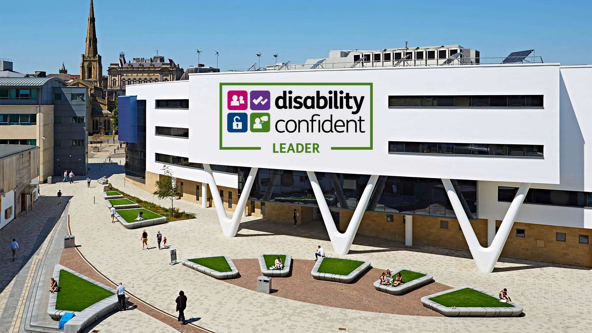 The student plaza at the University of Huddersfield with Disability Confident Leader logo