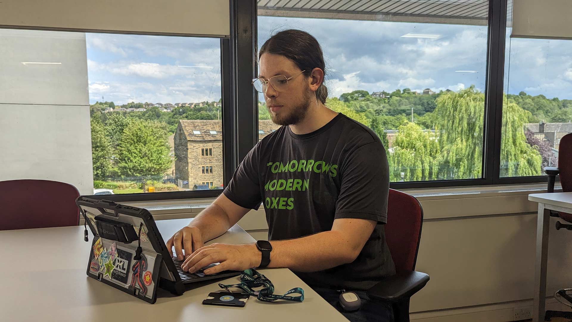 Joe sat at a desk, working on his tablet device.